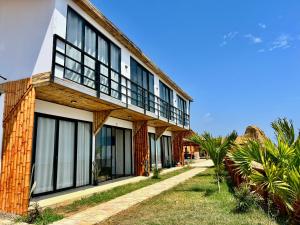 a building with black and white windows and palm trees at Casa Eyzaguirre - Zorritos in Bocapán