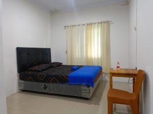 a bedroom with a bed and a table and a chair at Hotel Suka Indah in Cikembulan
