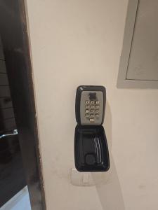 ein Mobiltelefon ist an einer Wand befestigt in der Unterkunft Stylish Apartment in New Admin Capital Celia Cairo in Madīnat al Amal + 100 Fotos