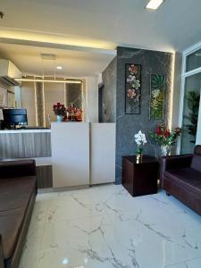 a lobby with a counter with flowers on the wall at Davao Persimmon Suites in Davao City