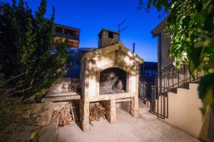an outdoor pizza oven is lit up at night at Apartments Pol Murvu in Vis