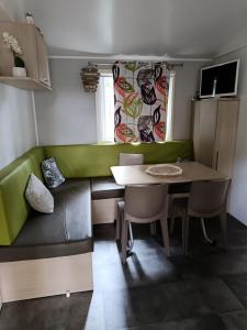 a living room with a table and a couch at Camping Mobil Home 6 Pers Rivage des Landes Piscine Landes in Aureilhan