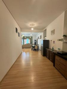 an empty kitchen and living room with a wooden floor at AYAAN Luxe Premium FIFA house with Free WiFi and Netflix in Tanah Rata