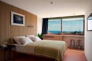 a bedroom with a bed and a large window at UP THERE design rooms in Split
