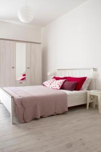 アルゲーロにあるLa camera chiaraの白いベッドルーム(赤い枕の大型ベッド付)