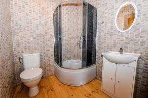 een badkamer met een toilet, een wastafel en een bad bij Poilsiavietė Elnias in Šventoji