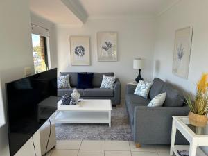a living room with a couch and a tv at Beautiful and Bright Penthouse in Hawks Nest +19 photos