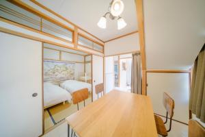 a room with a wooden table and a bed at INARI guest house 栗林公園徒歩3分 二棟貸切 駐車場一台無料 in Takamatsu