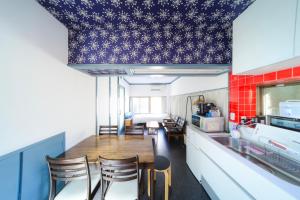 a kitchen with a table and chairs in a room at INARI guest house 栗林公園徒歩3分 二棟貸切 駐車場一台無料 in Takamatsu