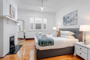 a bedroom with a large bed and a fireplace at Henley Beach House - Luxury by the Sea in Henley Beach +38 photos