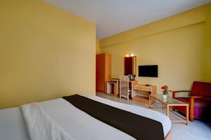 una habitación de hotel con una cama y un televisor en Hotel O ALT pods, en Bangalore