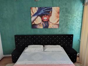Un dormitorio con una cama y un cuadro en la pared. en Apartament Justin, en Galaţi