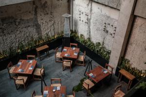 uitzicht op een restaurant met houten tafels en stoelen bij Hotel Casa Izel Roma Norte in Mexico-Stad