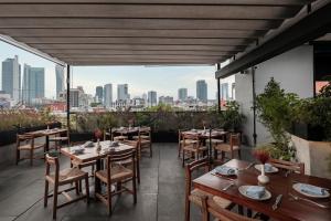 een restaurant met tafels en stoelen en uitzicht op de stad bij Hotel Casa Izel Roma Norte in Mexico-Stad