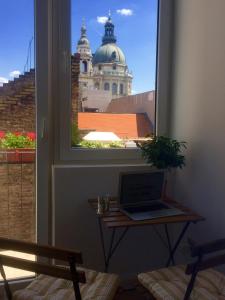 een laptop op een tafel voor een raam bij Ice Breaker Apartment in Boedapest