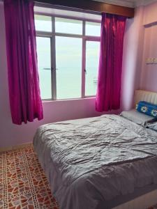 Schlafzimmer mit einem Bett mit rosa Vorhängen und einem Fenster in der Unterkunft Glory Beach Resort SEAVIEW in Port Dickson
