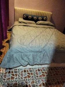 Bett mit blauer Bettdecke und Kissen darauf in der Unterkunft Glory Beach Resort SEAVIEW in Port Dickson
