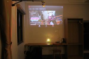 a projection screen on the wall of a room at Gạo Homestay-Hue in Hue