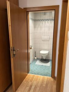 a bathroom with a toilet and a door open at Appartement Schneider in Sankt Anton am Arlberg