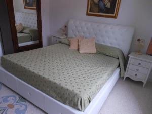 1 dormitorio con 1 cama grande y espejo en Ciddini, en Andrano