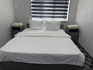 a large white bed with two pillows and a window at SILVER HOTEL navoiy in Navoi