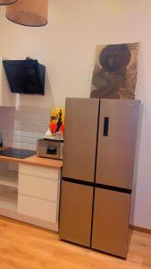 a kitchen with a refrigerator and a counter with a tv at Coumbis Faye in Brussels