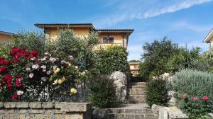 a house with flowers and stairs in front of it at B&B Casa del Pellegrino in Sutri