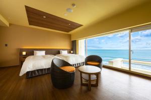 a bedroom with a bed with a view of the ocean at Kamogawa Grand Hotel in Kamogawa +95 photos