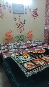 ein Schlafzimmer mit zwei Betten mit Mustern an der Wand in der Unterkunft Raghunath bhawan in Haridwar