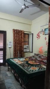 ein Bett in einem Zimmer mit Deckenventilator in der Unterkunft Raghunath bhawan in Haridwar