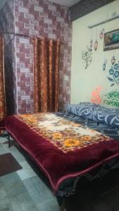 Bett in einem Zimmer mit Ziegelwand in der Unterkunft Raghunath bhawan in Haridwar