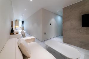 a living room with a white couch and a tv at The Central Hongdae in Seoul +85 photos