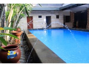 a large swimming pool with water coming out of it at PLUM Dreamscape Inan Malang in Rampal
