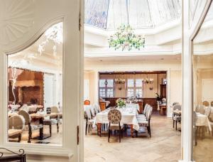 a dining room with tables and chairs and a glass ceiling at Burghotel Haselünne in Haselünne