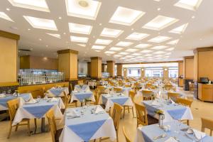 a dining room with tables and chairs with white tablecloths at Ibiscus Hotel in Rhodes Town