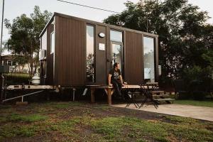 MontoMonto Magic by Tiny Away的一个男人坐在小房子前的桌子旁。