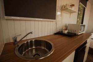 a kitchen with a sink and a laptop on a counter at Monto Magic by Tiny Away in Monto +4 photos