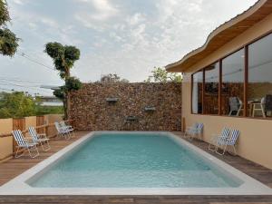 a large swimming pool with chairs and a house at Tamarind Pool Villa Kohlarn in Ko Larn