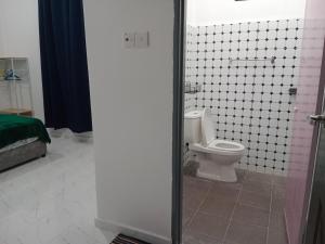 a bathroom with a toilet and a tiled floor at MUSYRIF HOMEstay in Kampong Gong Badak