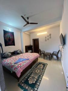 a bedroom with a bed and a ceiling fan at Budhibhaihomstay in Bīr