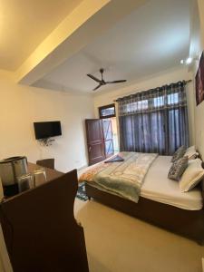 a bedroom with a bed and a ceiling fan at Budhibhaihomstay in Bīr