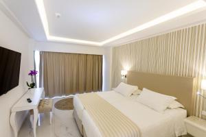a hotel room with a large bed and a desk at Ibiscus Hotel in Rhodes Town