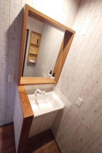ein Badezimmer mit Waschbecken und Spiegel in der Unterkunft Hyuga Surf Camp107 - Vacation STAY 29756v in Hyuga