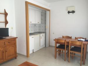 cocina con mesa de madera y comedor en Apartamentos Santi, en Lloret de Mar