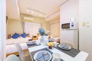 a room with a bed and a table in a room at 栄エリア徒歩圏の好立地 栄まで1駅 名古屋駅まで乗換不要 地下鉄最寄り駅徒歩9分 最大5名 in Nagoya