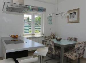 a kitchen with a table and chairs and a window at Apartments K Supetar in Supetar