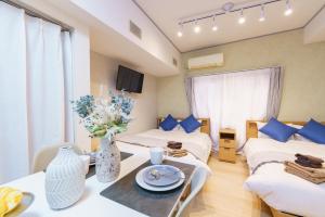 a hotel room with two beds and a table at 栄エリア徒歩圏の好立地 栄まで1駅 名古屋駅まで乗換不要 地下鉄最寄り駅徒歩9分 最大5名 in Nagoya