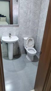 Un baño con lavabo, inodoro y espejo. en Abuja luxury apartment, en Abuja