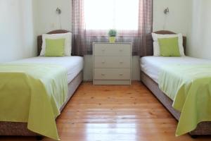 two twin beds in a room with wooden floors at Apartments Villa Milna 1 in Budva