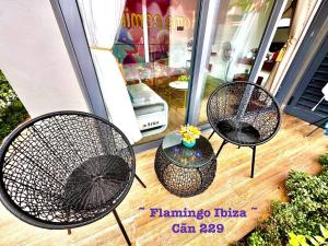three chairs and a table on a porch at Flamingo Hải Tiến IBIZA in Gò Ba Quần